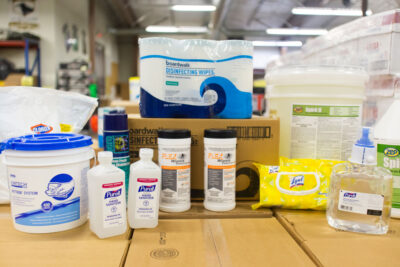 A group of cleaning supplies such as hand sanitizers and Clorox wipes.